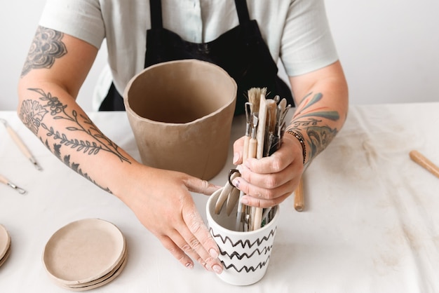 Young woman making earthen pot in pottery workshop