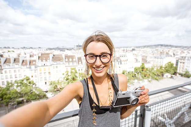 Photo young woman making selfie photo on the paris skyline background