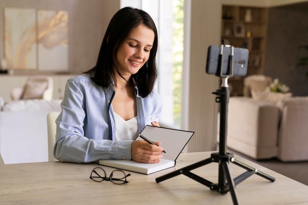 Young woman making a vlog at home with her phone