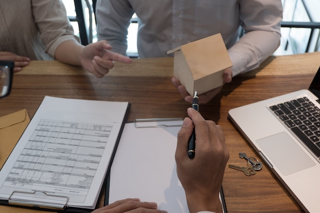 Young woman and man signing contract making a deal with  real estate agent.