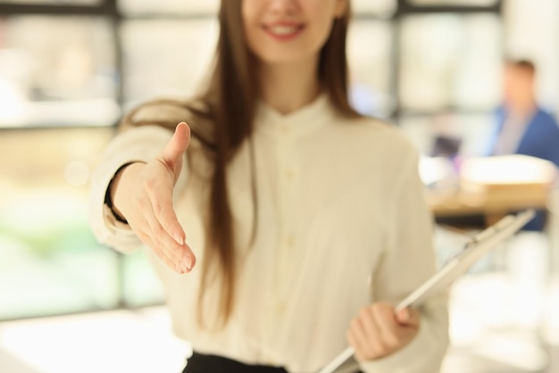 Young woman manager offers her hand for handshake in office concept of welcoming recruitment