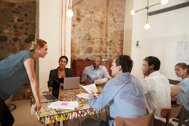 Young woman managing a team meeting in a boardroom close up