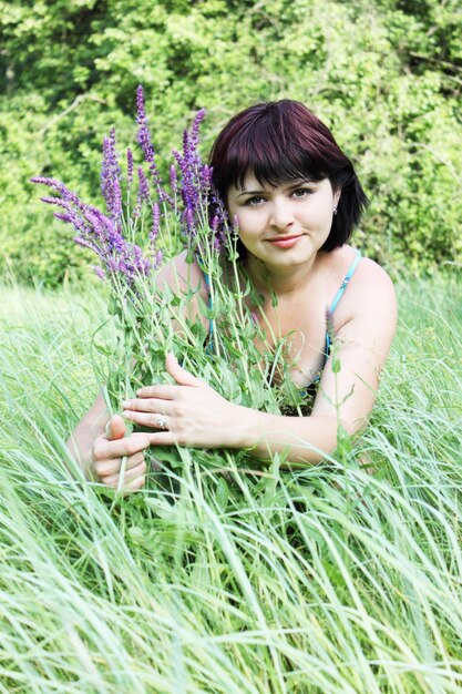 Young woman on to meadow with the flowers