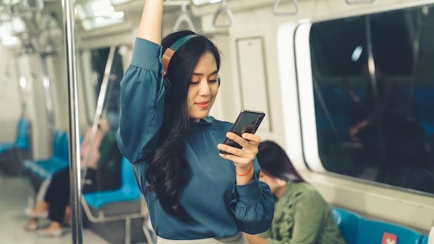 Young woman mobile phone on public train  Urban city lifestyle commuting concept