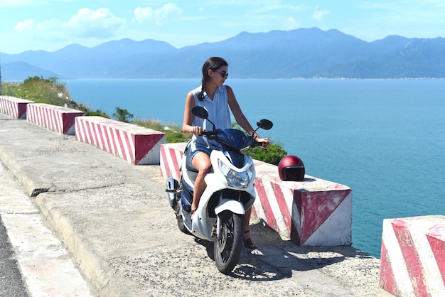 Young woman motorbike driver sitting against south south china sea in vietnam