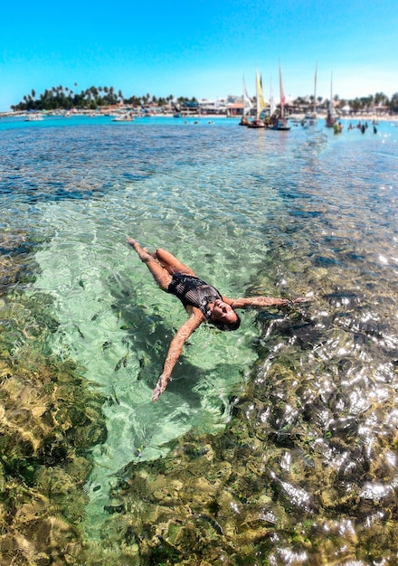 Young woman in natural pools in Porto de Galinhas Pernambuco swimming with fish