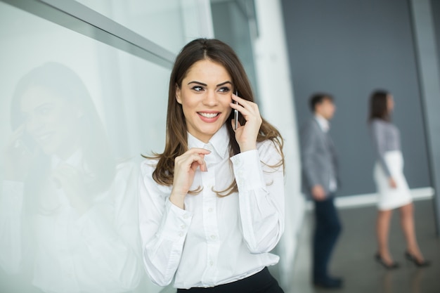 Young woman in office with mobile phone