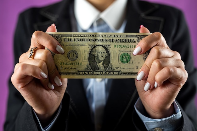 Young woman office worker holding dollars currency wealthy isolated on single color background