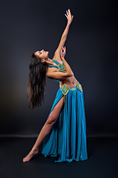 Young woman in oriental dance on the black background