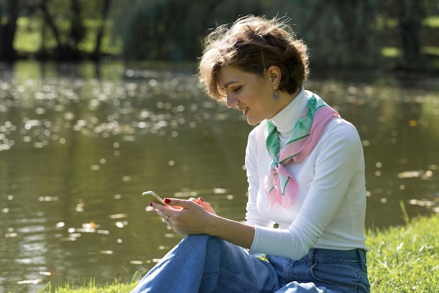 Young woman in the park speaks by mobile phone Cute girl portrait in french style