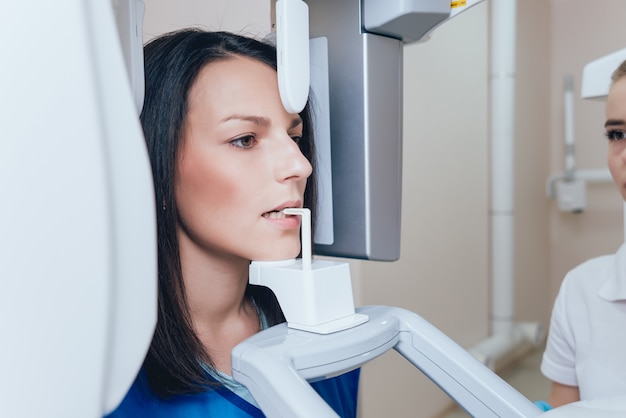 Young woman patient standing in x-ray machine.