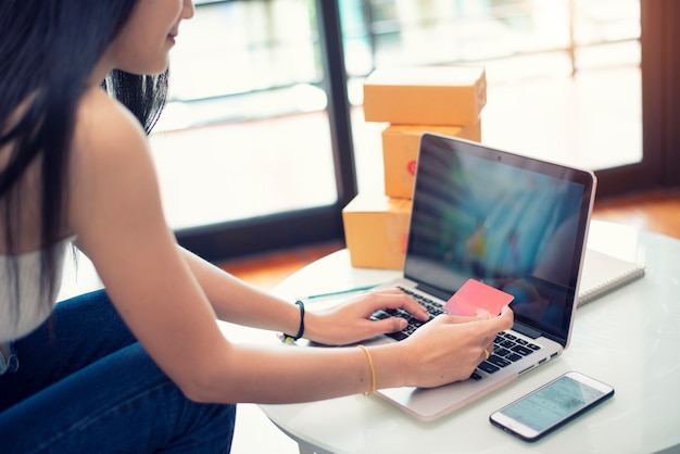 Young woman paying shopping online with a credit card at home