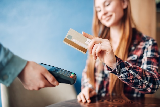 Young woman paying with credit card in cafe