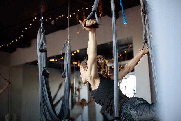 A young woman performs a yoga exercise in a fitness class