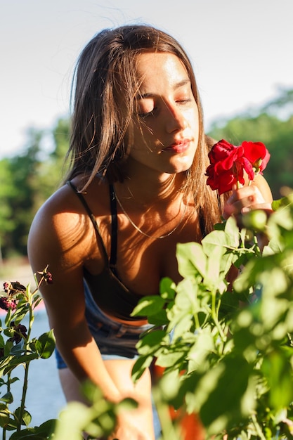 Young woman picking a rose in a field