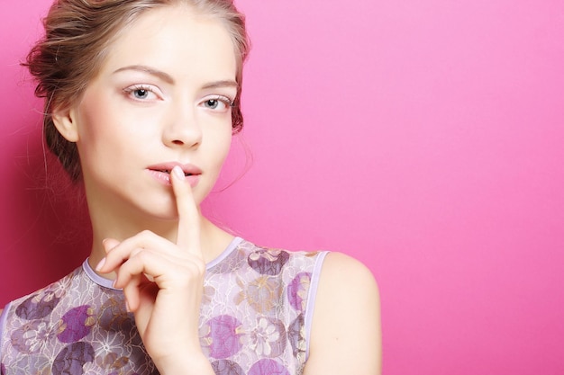 Young woman over pink background