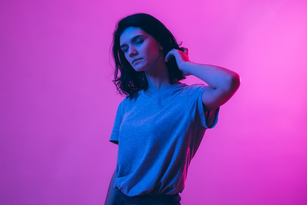 Young woman in pink blue neon lights.