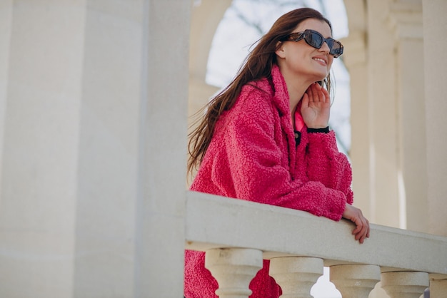 Young woman in pink coat standing in the street