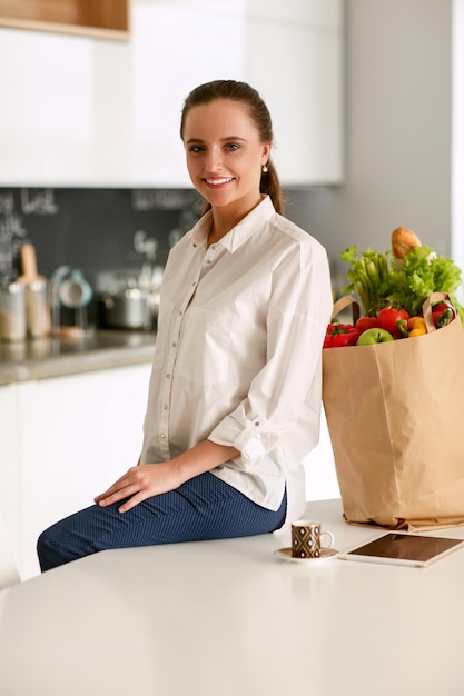 Young woman planning expenses and paying bills on her kitchen