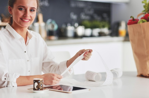 Photo young woman planning expenses and paying bills on her kitchen