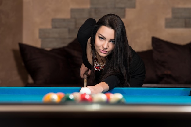 Young Woman Playing Billiards Lined Up To Shoot Easy Winning Shot