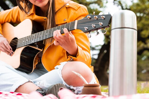 young woman playing guitar in a park