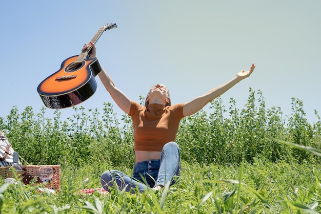 Young woman playing guitar on a picnic