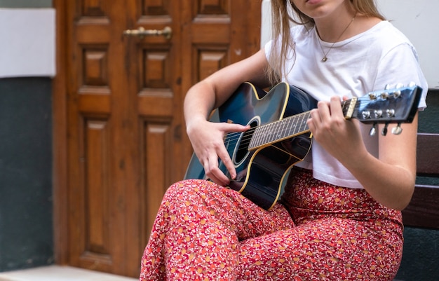 Young woman playing guitar on the street