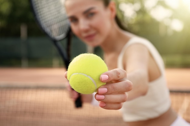 Young woman playing tennis at court focus on ball