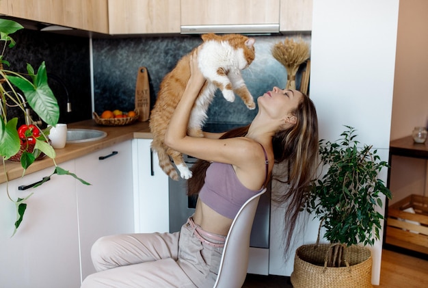 Young woman playing with cat at home