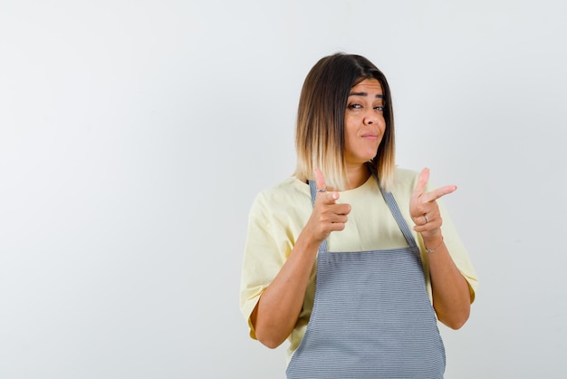 Young woman pointing something with her fingers on white background