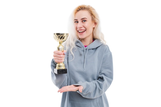 A young woman poses with a golden cup on a white background Winning competitions