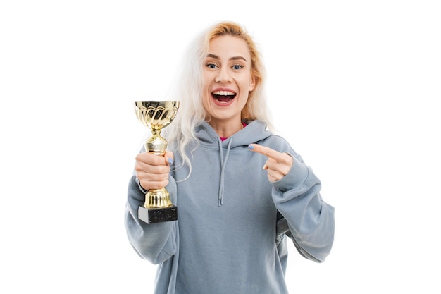 A young woman poses with a golden cup on a white background Winning competitions