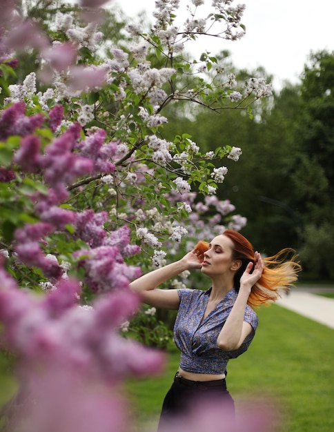 Young woman posing in lilac blossom