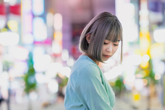 Young woman posing in Tokyo city at night