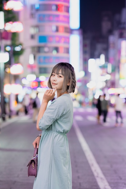 Young woman posing in Tokyo city at night