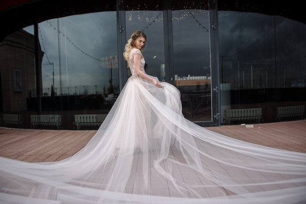 Young woman posing in a white wedding dress