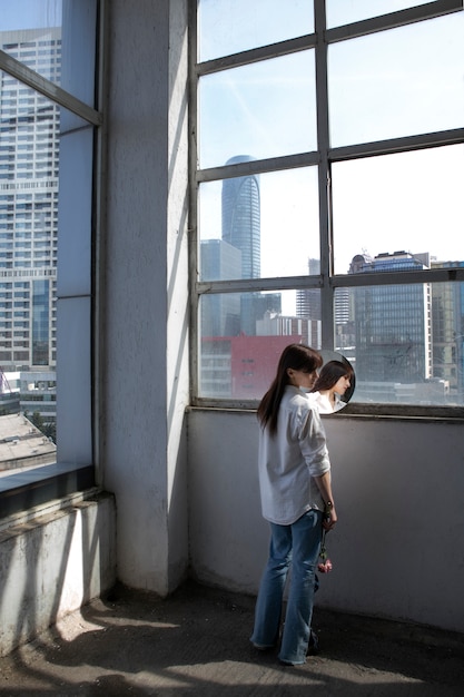 Photo young woman posing with mirror inside building next to window