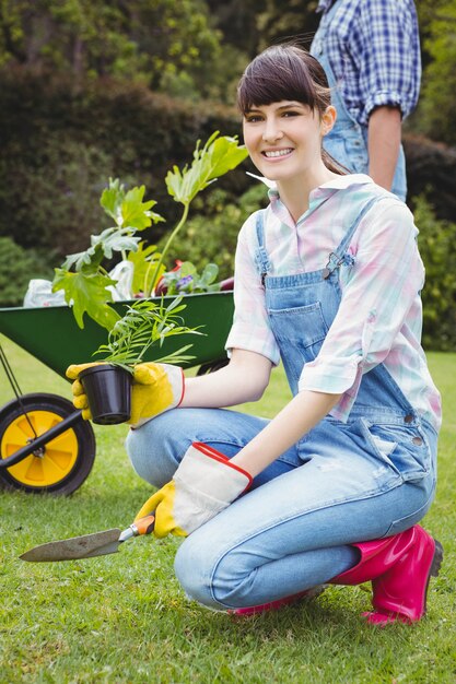 Young woman potting a plant in garden