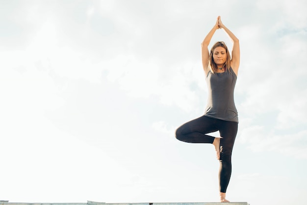 Young woman practices yoga outside