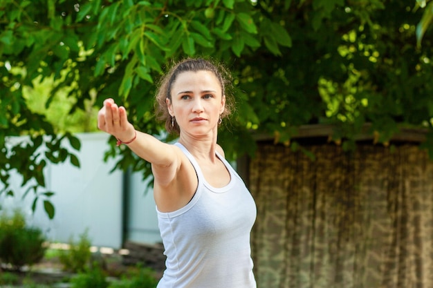 Young woman practices yoga in the summer garden Natarajasana Lord of the Dance Pose or Dancer Pose