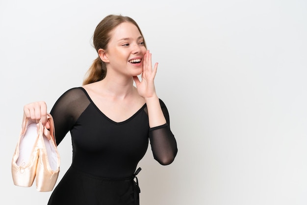 Young woman practicing ballet isolated on white background shouting with mouth wide open to the side