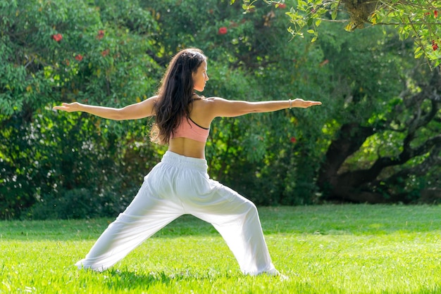 Young Woman Practicing Yoga on a Green Park in a Sunny DayWellness ConceptCopy Space