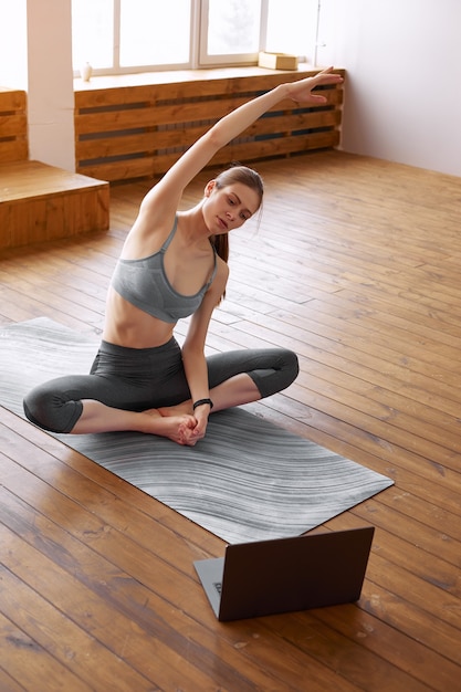 Young woman practicing yoga at home