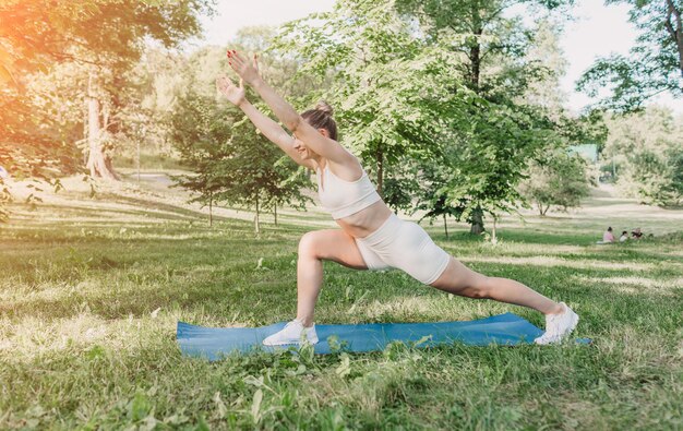 A young woman practicing yoga outdoors in the morning at dawn healthy lifestyle