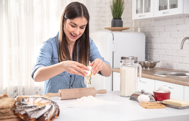 Young woman preparing homemade cakes in the spacious bright kitchen.