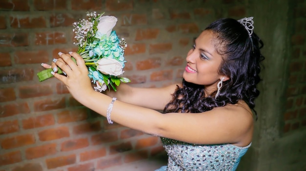 Young woman in a princess costume and a bouquet of flowers in her hand.