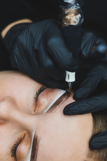 Young woman during professional eyebrow mapping procedure before permanent makeup