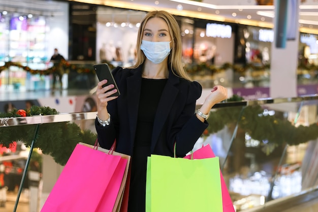 Young woman in protective mask with shopping bags