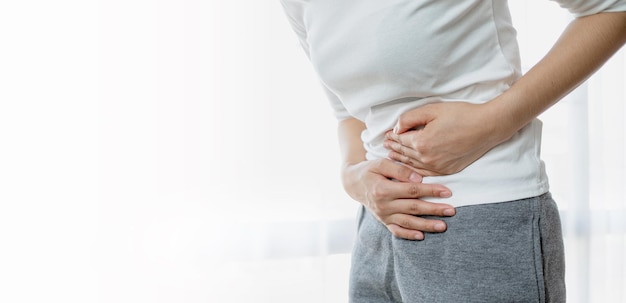 Young woman put her hand on her stomach because she had a very bad stomachache menstrual pain gastritis or diarrhoea Healthcare medical concept